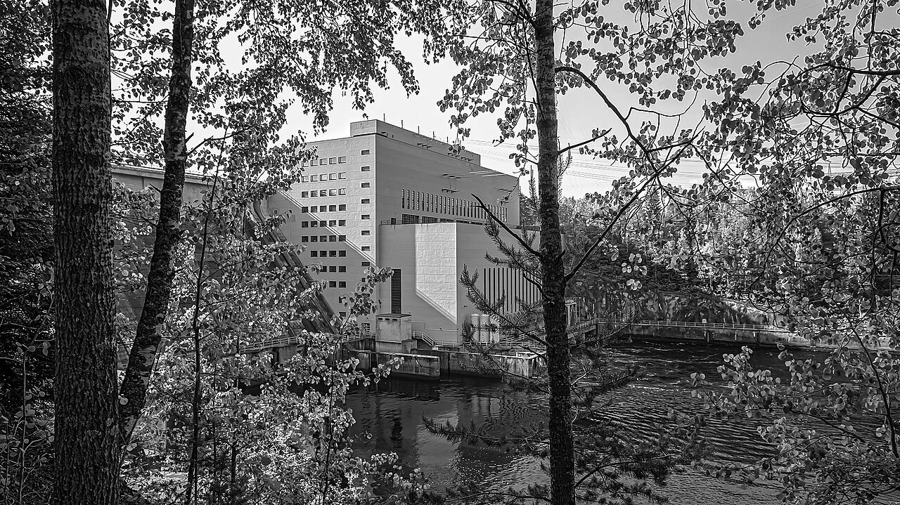 Kuva vaaleasta rakennukesta ja koskesta