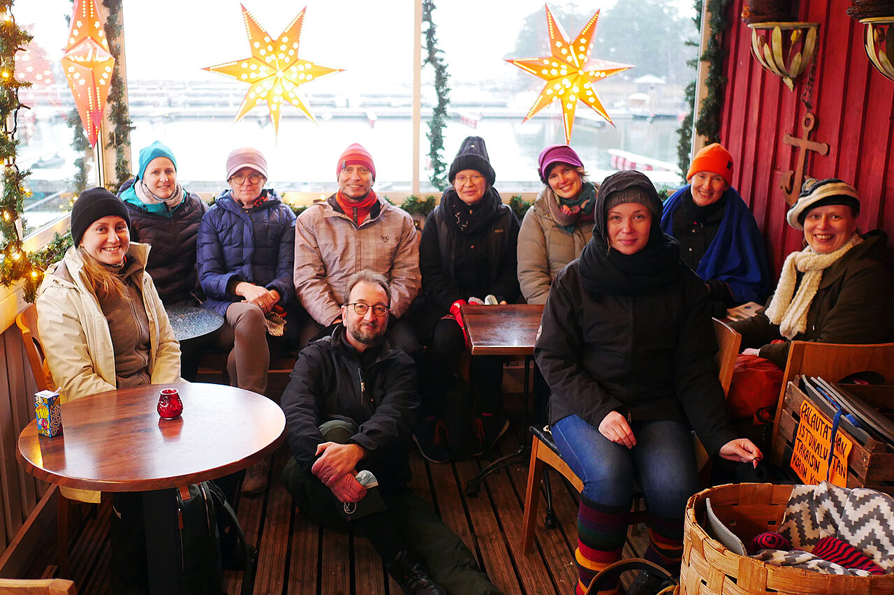 Joukko ihmisiä pöydän äärellä.