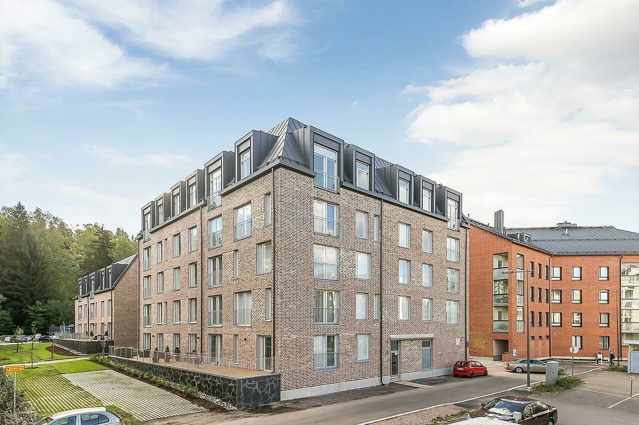 Espoon keskuksen uudet asumisoikeustalot. Talot ovat moderneja tiilitaloja, mutta lainaavat vanhaa: peltikatosta avautuvat hauskasti ylimmän kerroksen ikkunat.