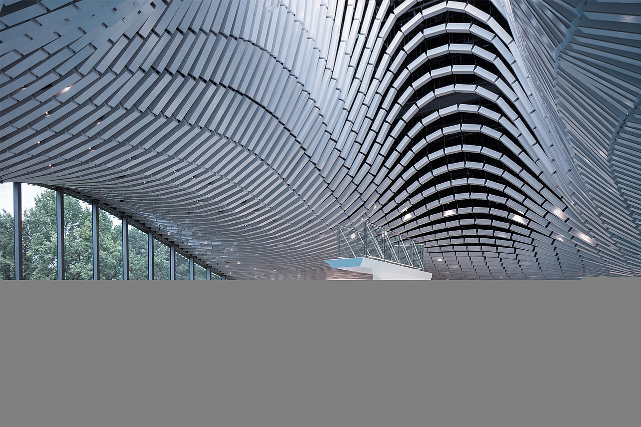 Uimahalli, jonka katto on aaltoileva ja raidallinen.