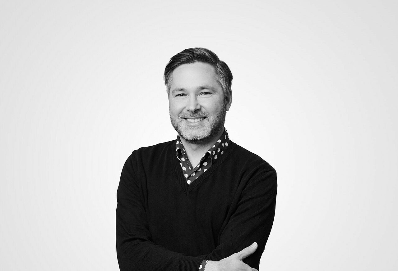 Hymyilevä mies katsoo kameraan