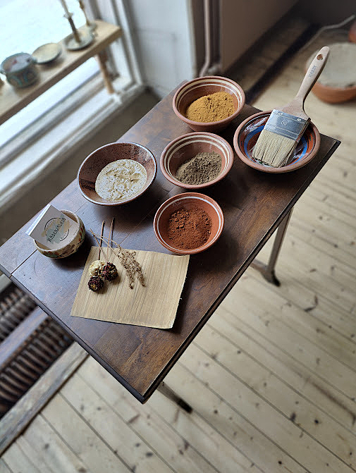 Pöytä, jolla on kulhoissa erilaisia värillisiä jauheita