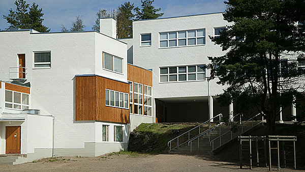 Kuva koulusta, jossa on valkoinen julkisivu.