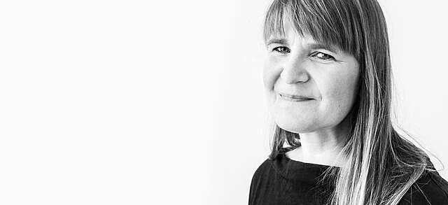 A black and white portrait of a smiling woman