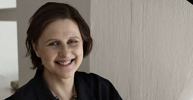 Nainen hymyilee kameralle