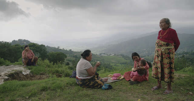 Four Nepali women and a young boy having an outdoors picnic