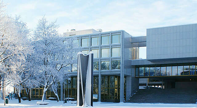 Vaalea rakennus, jossa neliönmuotoisia ikkunoita