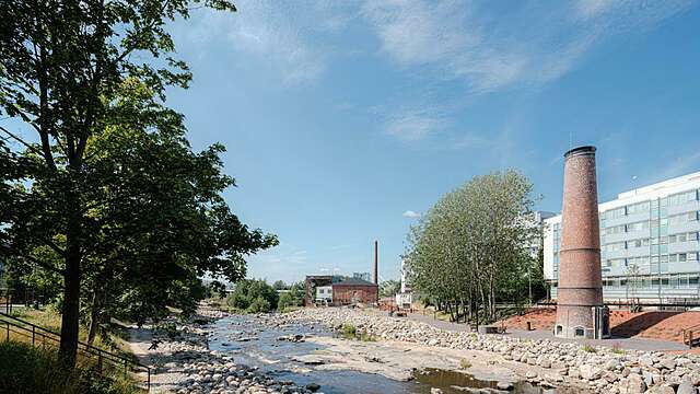 Maisema tehdasalueelta, jonka läpi kulkee pato