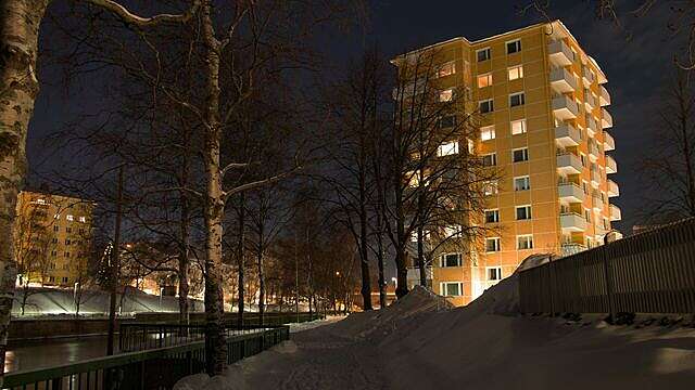 Keltainen kerrostalo yövalaistuksessa