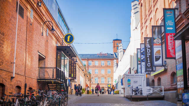 A street view between red brick buildings of an industrial flare.