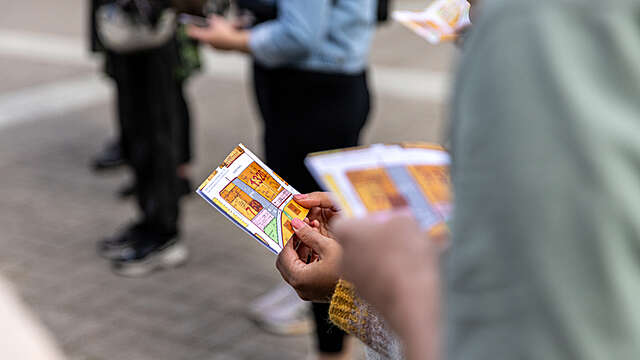 A person holding artwork resembling a map.