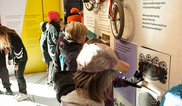 Lapsia katselemassa näyttelytekstejä.