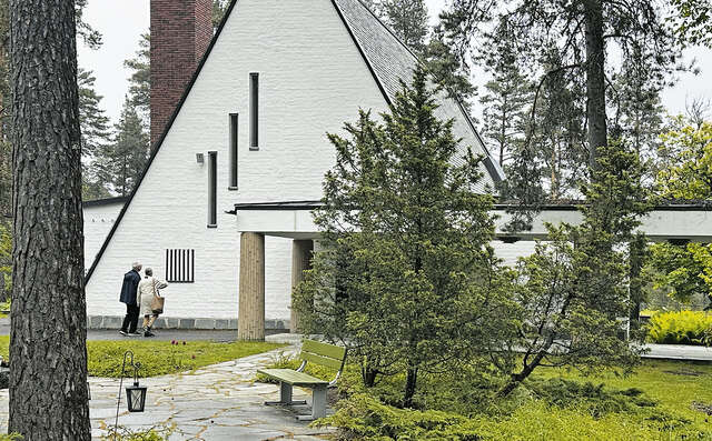 Kaksi ihmistä katsoo kolmion muotoista rakennusta