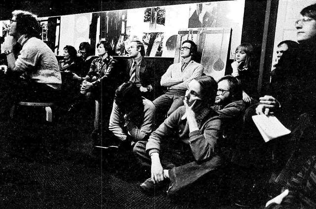 Vanha mustavalkovalokuva joukosta pohdiskelevia ihmisiä.