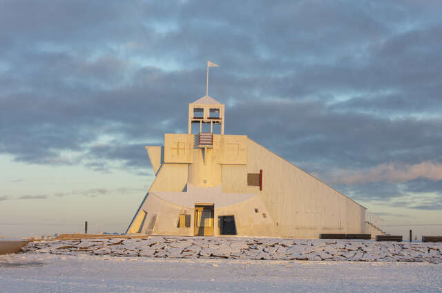 Majakanmuotoinen rakennus meren äärellä