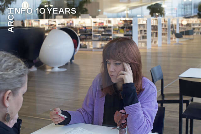 Two women discussing at a table in a library space