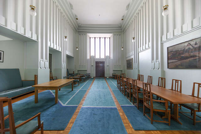 jugendtyylinen odotussali, jossa vanhoja saman aikakauden huonekaluja ja tauluja seinillä.