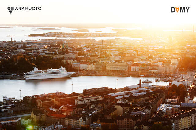 Ilmakuva auringonlaskusta merenrantakaupungin yllä