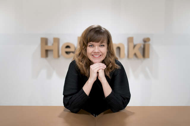 Nainen, taustalla Helsinki-teksti.