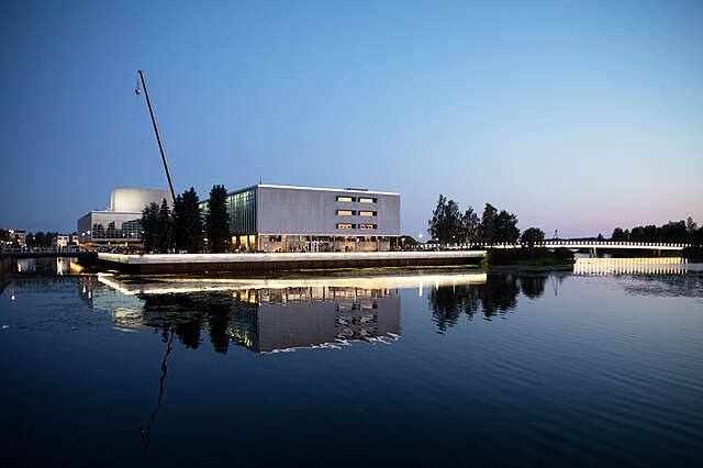 Betonirakennus ja silta heijastuu veteen.