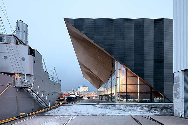 Modern building with stone, wood and glass elements on the harbour.