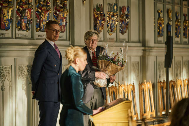 Mies vastaanottamassa kukkakimppua.