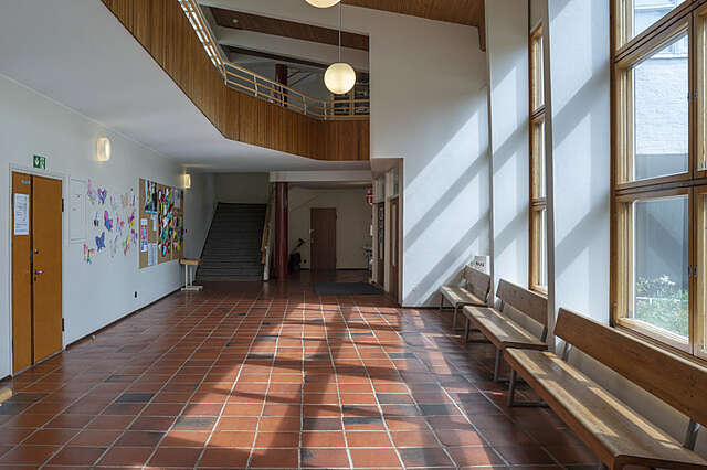 Sisätila, tiililaattalattia, ylemmän kerroksen kaiteessa puuta