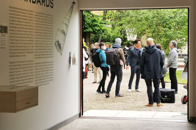 A crowd of people gathered outside the pavilion building.