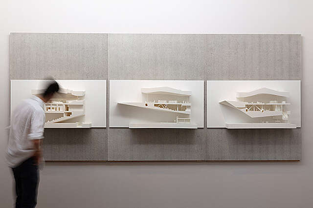 Kolme valkeaa pienoismallia seinällä