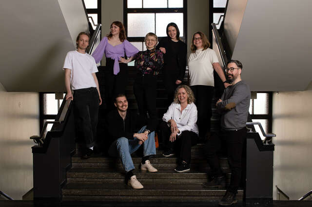 The picture shows a group of people on a staircase.