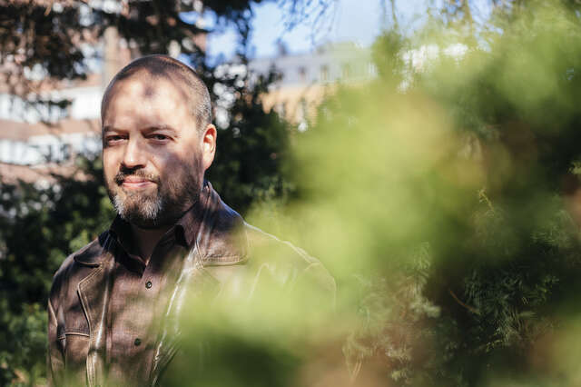 The picture shows the man behind the canopy. The man is looking directly at the camera.