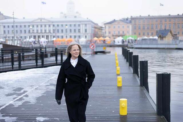 Nainen kävelee satamalaiturilla