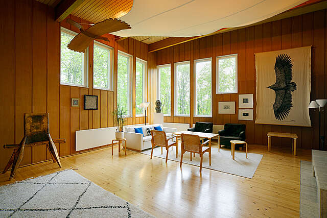 Kuva huoneesta, jossa puiset seinät ja eri korkuiset ikkunat.