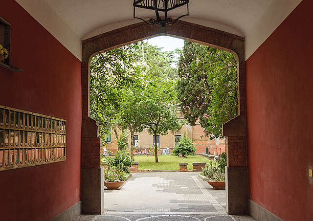 A green courtyard can be seen through the gatekong.