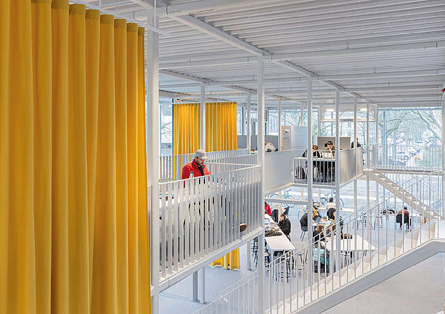 Valoisa sisätila, jossa keltainen verko tilajakajana.