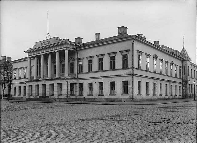 Vanha mustavalkovalokuva historiallisesta rakennuksesta.