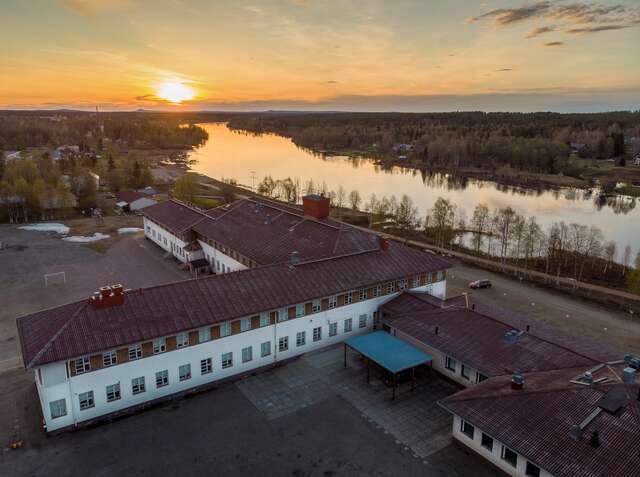 Ilmakuva koulurakennuksesta, taustalla keskiyön aurinko.