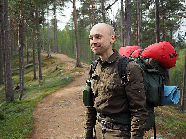 Man with hiking gear in a forest.