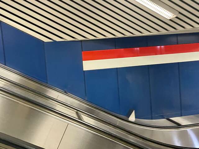 Liukuporras, taustalla sininen seinä jossa punainen ja valkoinen raita