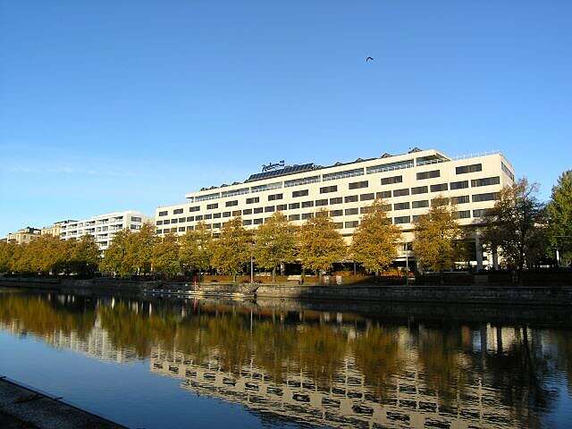 Pitkä vaalea kerrostalo joen rannassa