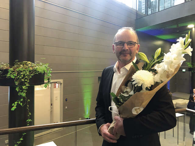 Man holding a bouquet of flowers.