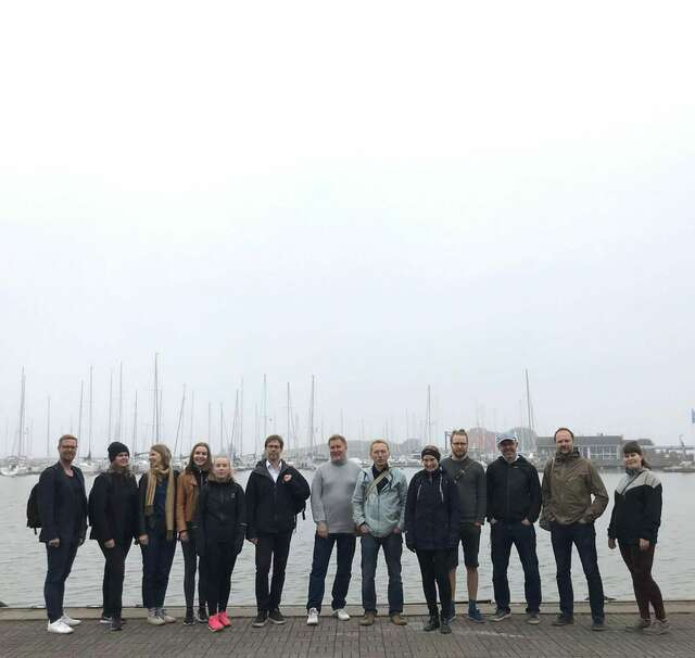 A group of people standing in front of a harbour.
