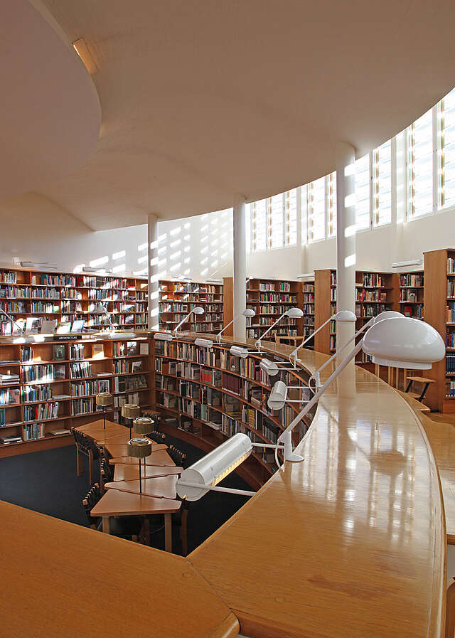 Kirjastorakennus nähtynä sisältä auringon valon paistaessa sisään lukusaliin rakennuksen yläikkunoista.