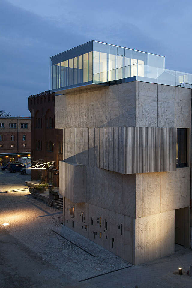 Evening view from the top vista towards the boxy, sculptural building