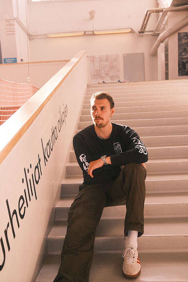 Young man sitting on stairs.