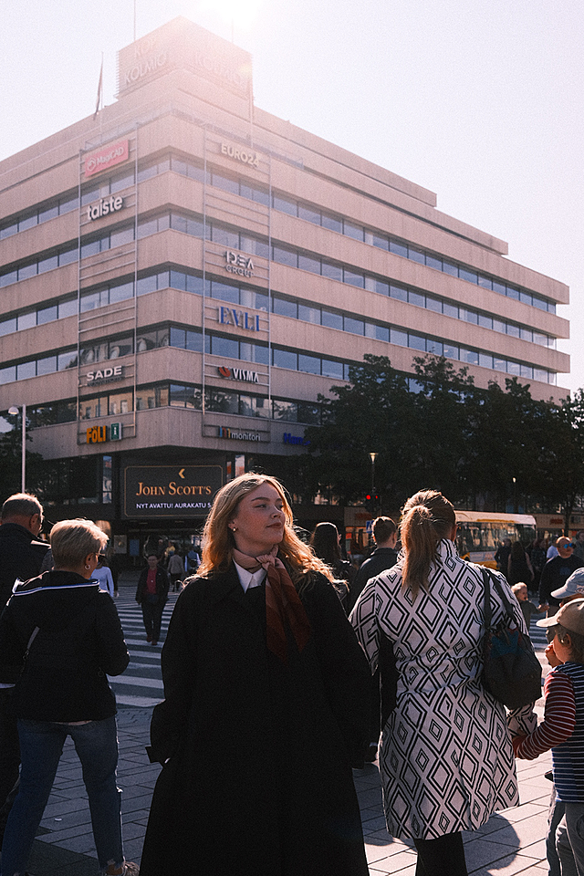 Woman standing in front of a commercial building.