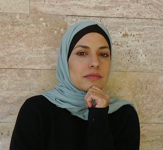 Nainen hijab-huivissa katsoo kameraan