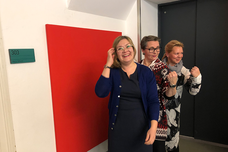 Hanna Kapanen, Leena Svinhufvud sekä Arja-Liisa Kaasinen iloitsevat ja poseeravat kameralle punaisen taidetoksen edessä.