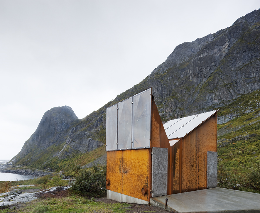 Small restroom building made of corten steel, steel and glass in a mountainous scenery.