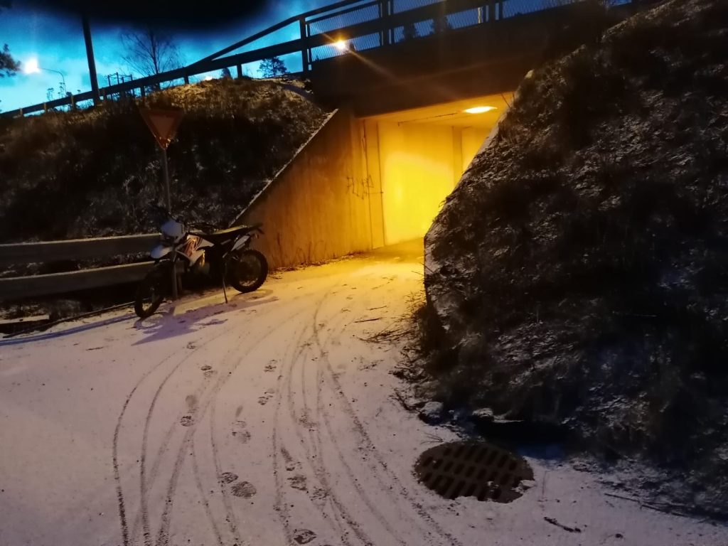 Luminen näkymä alikulkusillalle, jonka sisäänkäynnin vieressä on moottoripyörä.
